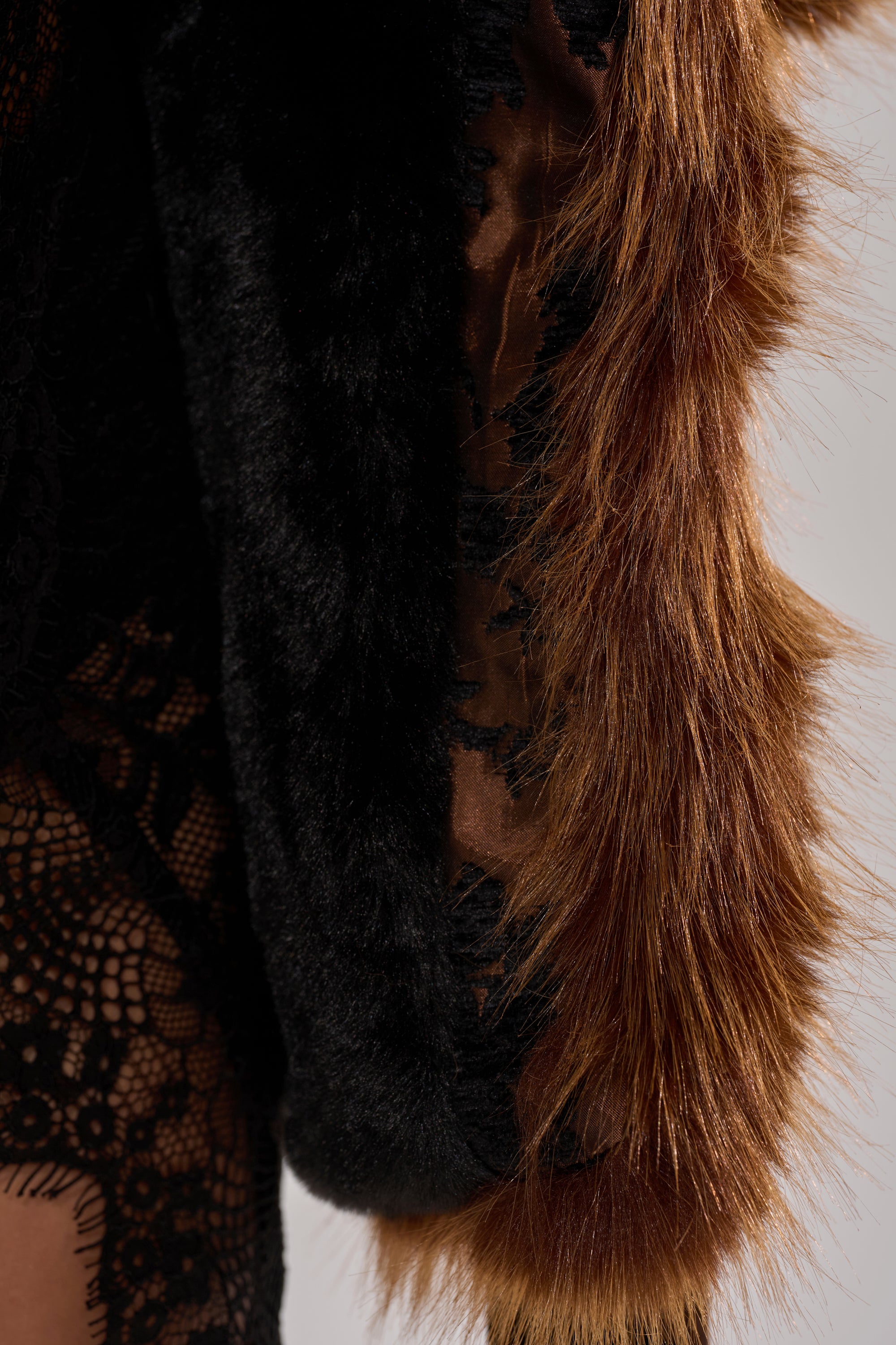 A close-up of the KENZY FUR TRIM MOTO IN JACQUARD showcases black lace, a faux fur collar, reddish-brown accents, and layered textures reminiscent of a floral jacquard jacket.