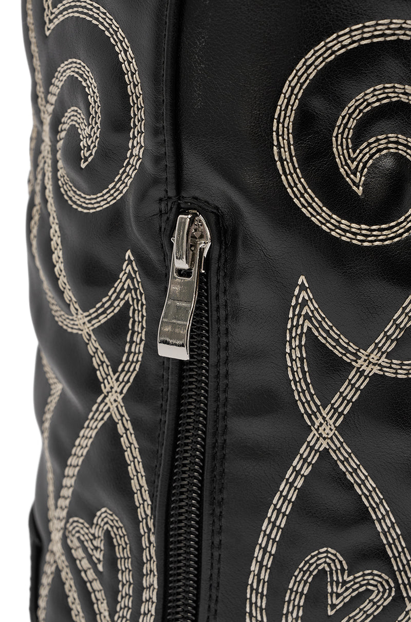 Close-up of the AZALEA WANG KESS BLACK WESTERN THIGH HIGH CHUNKY BOOT featuring a silver zipper on black faux leather, detailed with intricate white embroidery. 8