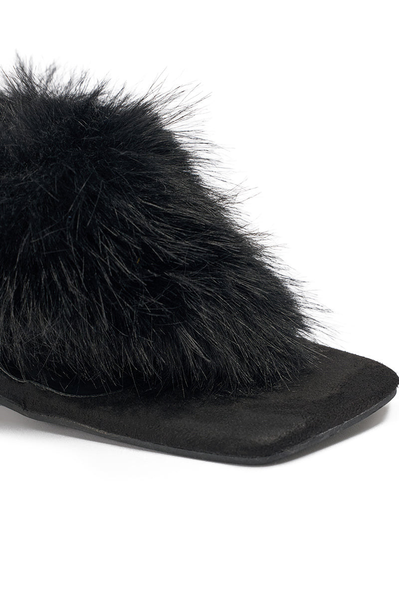 Close-up of the AKIRA GOLD KIRI BLACK FUR THONG SANDAL, featuring a black faux fur upper and a clear wedge heel with a flat, square-shaped sole. 6