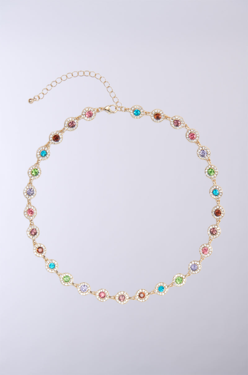 The ITS GIVING LUXURY CHOKER is a delicate and exquisite piece featuring a gold chain adorned with small, round gemstones in blue, purple, green, pink, and amber hues arranged in a repeating pattern. The adjustable clasp and series of chain links ensure a customizable fit, adding an elegant touch to this luxurious choker. 2
