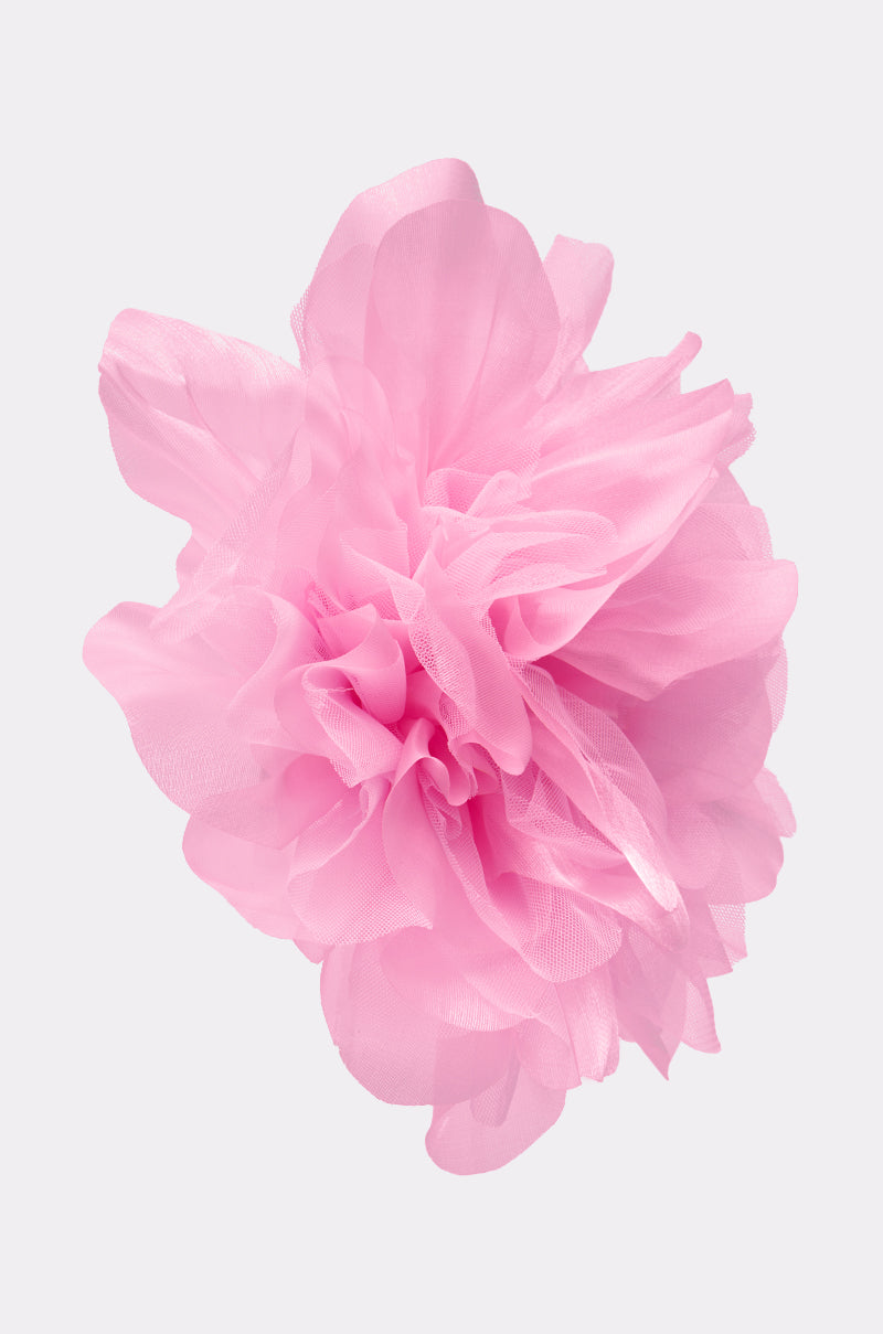 The OVERSIZED FLOWER STUD EARRING IN PINK features a large, fluffy pink fabric flower with layered, translucent petals, showcased against a plain light gray background. 4