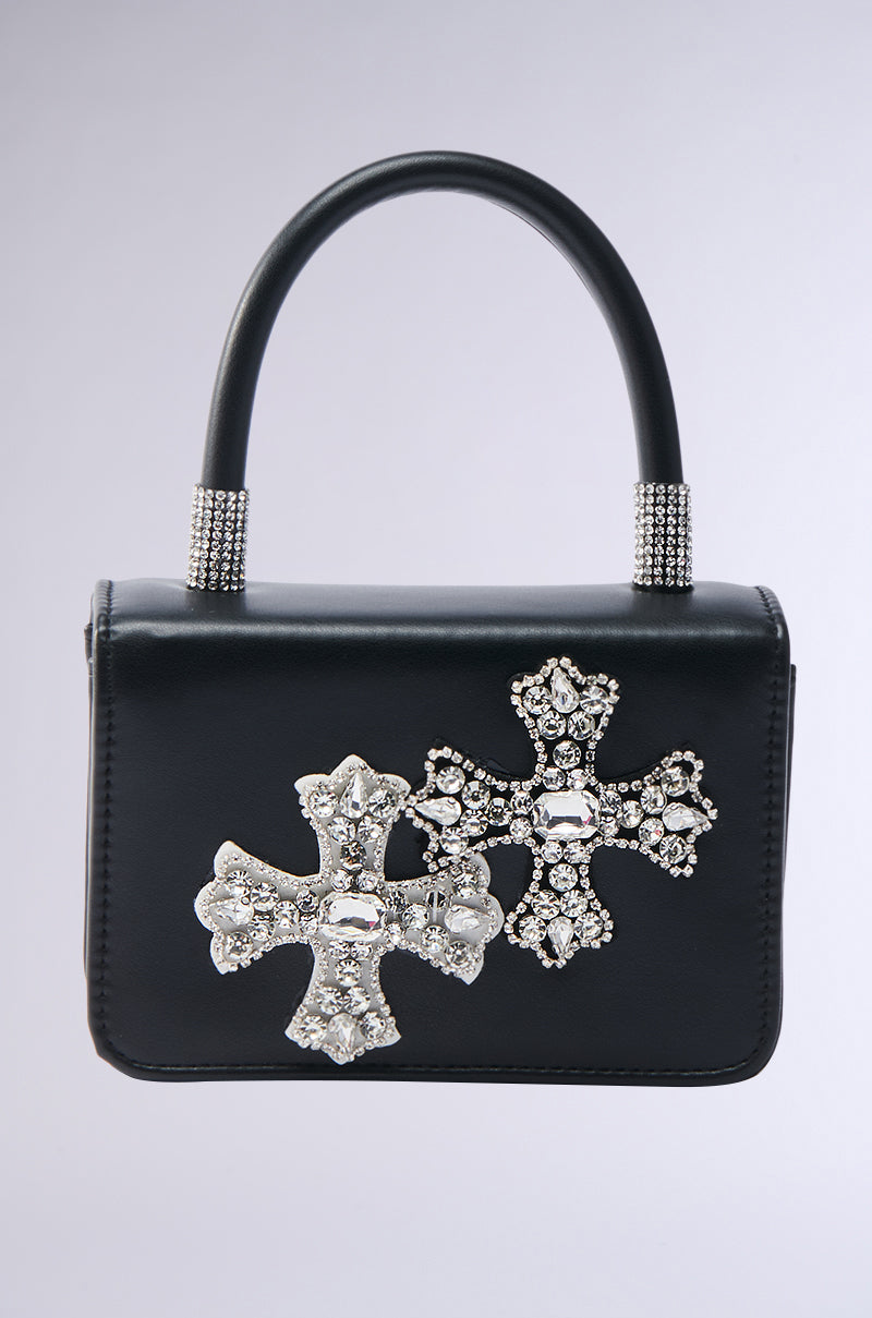 The EVERYTHING CHROME PATCH PURSE is a small black handbag with a short handle and crossbody fit, featuring two large silver jeweled cross designs with sparkling rhinestone accents on the front.