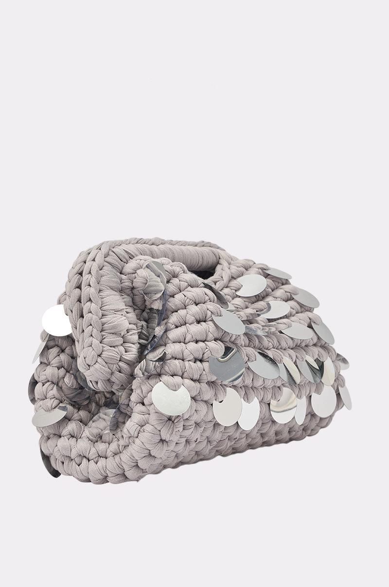 The UNDER THE LIGHTS CROCHET SEQUIN CLUTCH is a small, light gray bag embellished with shiny silver sequins, shown against a plain white background—ideal as a chic grey party clutch for any occasion. 2