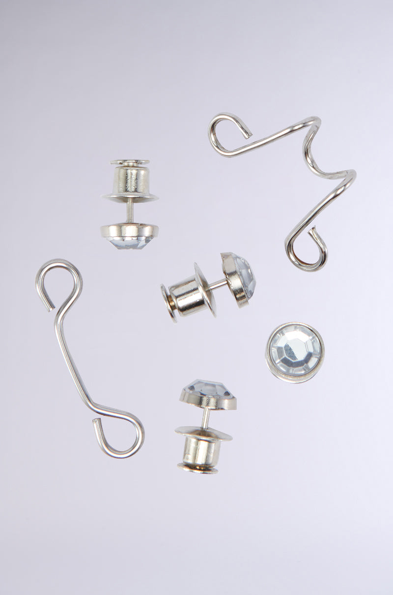 A collection of uniquely designed silver BLING LIFE PANT ADJUSTER pieces, including hooks and studs, set against a plain gray background. These pieces boast shiny, faceted crystal-like details with subtle rhinestone embellishments. 1