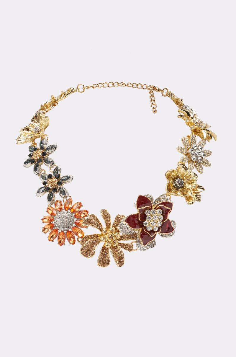 The REALLY HER STATEMENT NECKLACE is a bold rhinestone floral piece with ornate gold, red, black, and silver flowers and sparkling accents—perfect for a summer date night—shown on a plain white background.