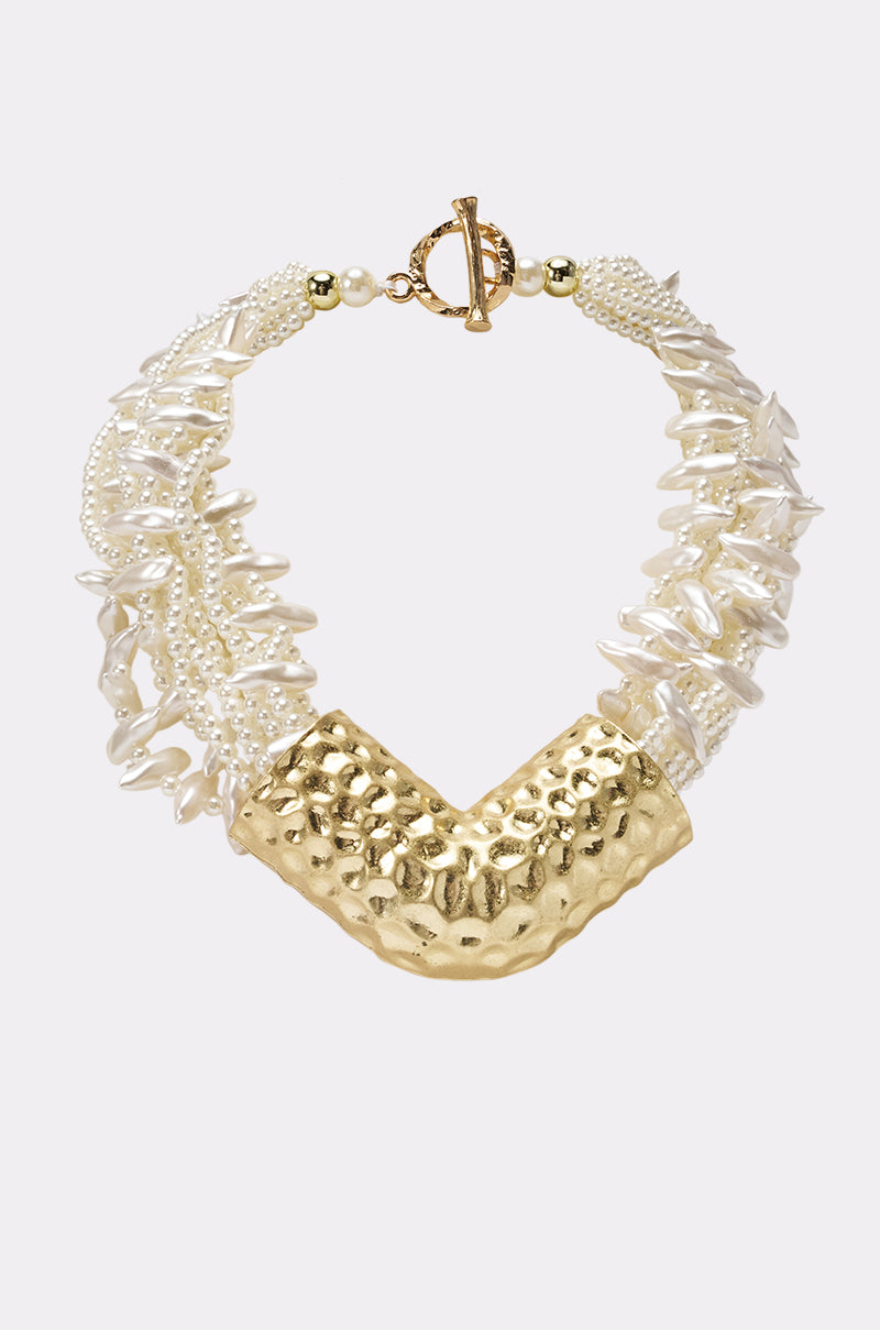 The CLEARLY NECKLACE is a chunky layered piece with irregular white pearls, small beads, a bold textured gold V-shaped centerpiece, and a gold toggle clasp—ideal for fans of statement pearl chokers.