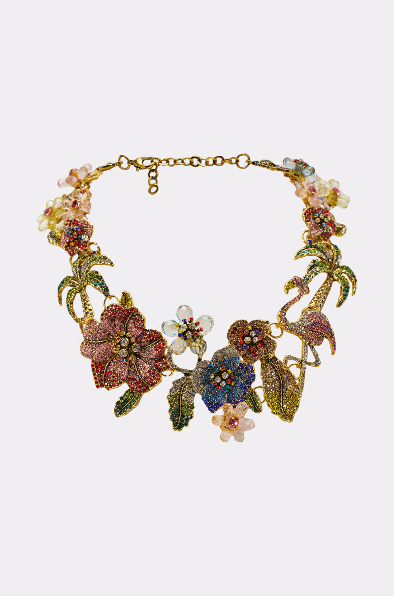 The IN THE GARDEN STATEMENT NECKLACE features jeweled flowers and leaves in pink, blue, green, and yellow rhinestones—a vibrant choice to add colorful elegance to your getaway look as standout vacation jewelry. 0