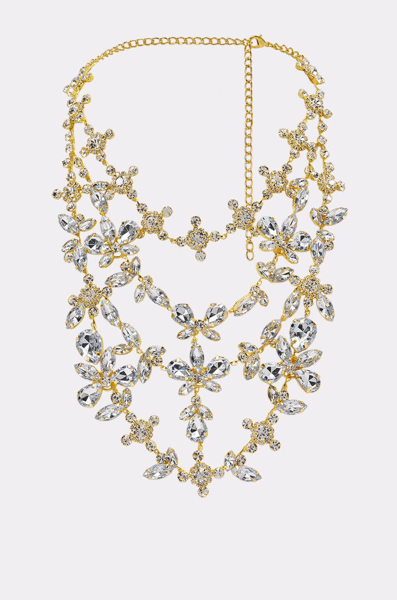Introducing the DRAMA NECKLACE—a stunning gold-tone statement piece featuring three rows of sparkling clear crystals arranged in elegant floral designs with an adjustable chain clasp. Perfect as bridal jewelry or a wedding necklace to complete your special day look.