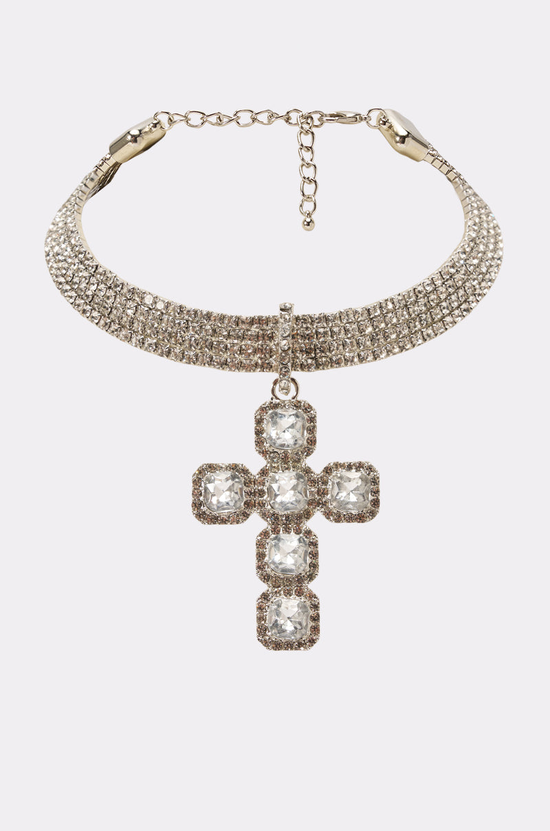 Introducing the CHOKED ON JESUS NECKLACE IN SILVER: a stunning silver rhinestone collar necklace, encrusted with small rhinestones and featuring an ornate cross pendant adorned with square-cut clear gemstones. This bold statement piece effortlessly combines elegance with eye-catching style.