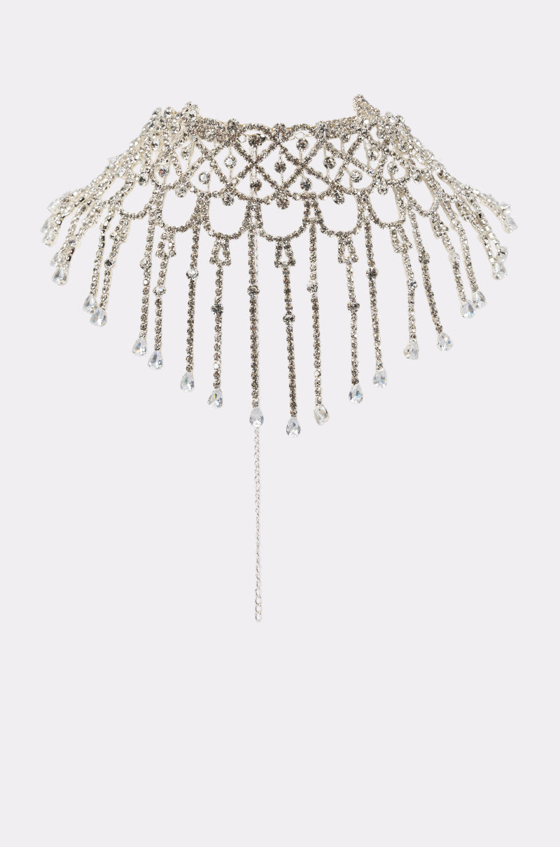 The CAE NECKLACE features a jeweled crystal collar with an intricate lattice design and cascading chains tipped with sparkling crystals, shown on a white background—an elegant birthday jewelry choice.