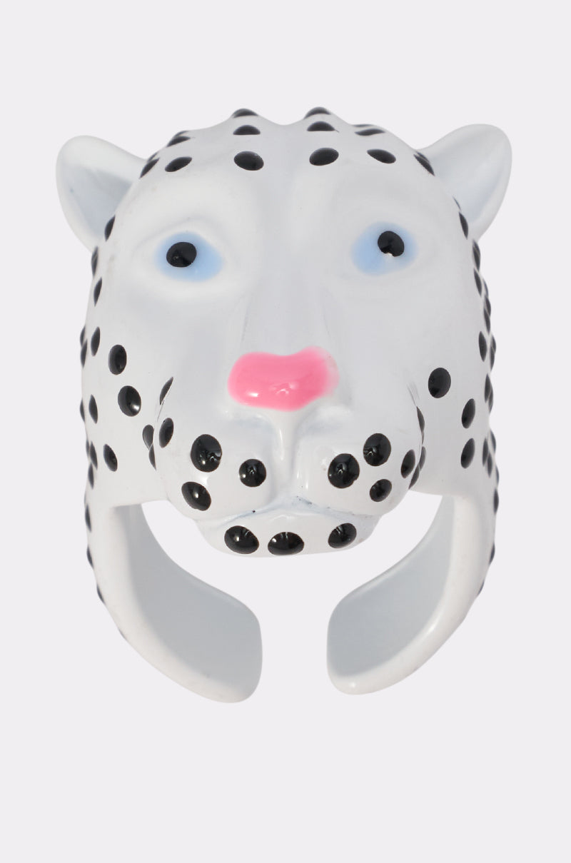 The DOTTIE COCKTAIL RING is a leopard-head inspired piece with black spots, light blue eyes, and a pink nose. This adjustable feline-themed ring is displayed against a plain light background.