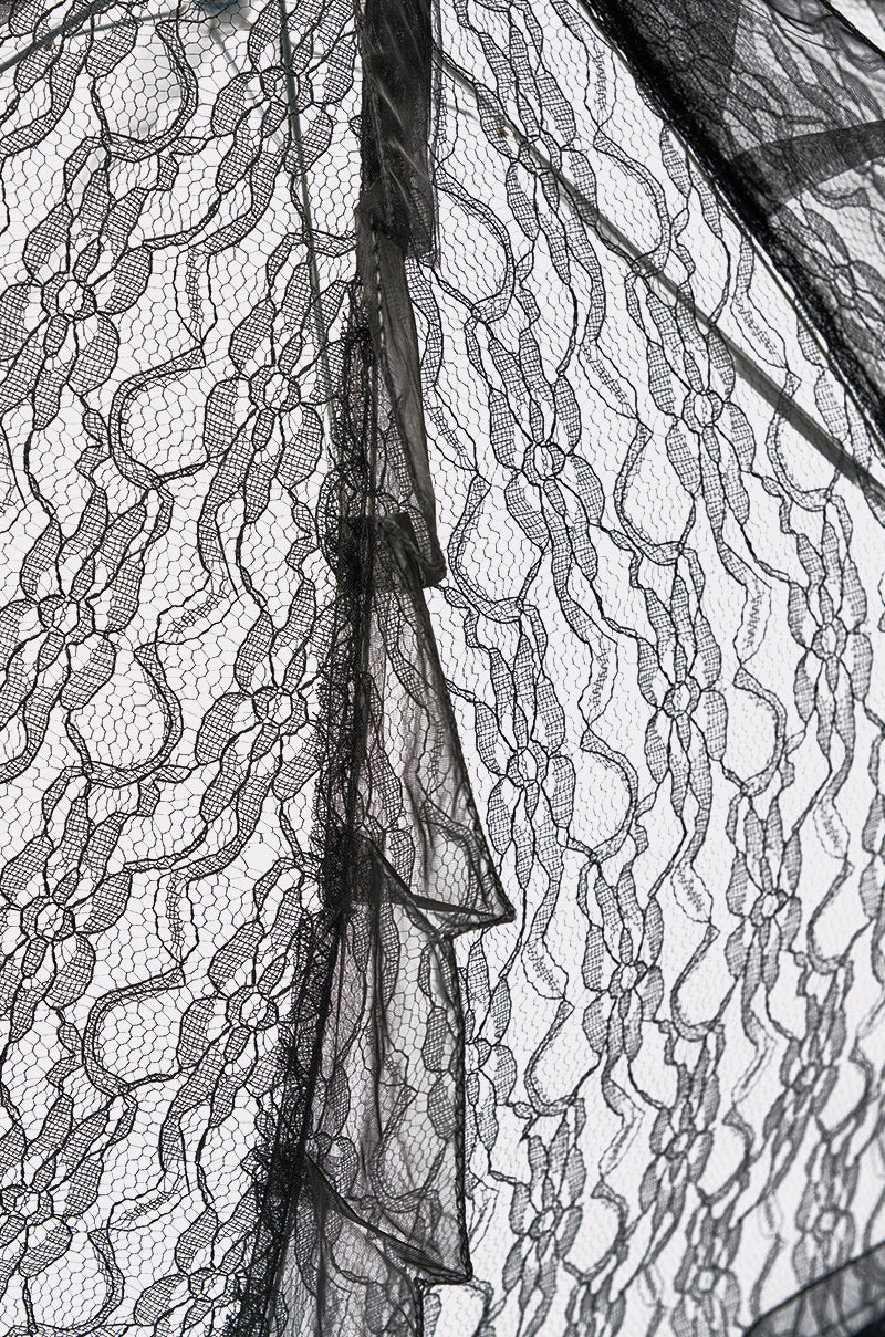 Close-up of the UNDER MY SPELL LACE UMBRELLA, featuring black floral lace and sheer overlapping layers, reminiscent of vintage style with scalloped edges for an intricate, textured look. 8