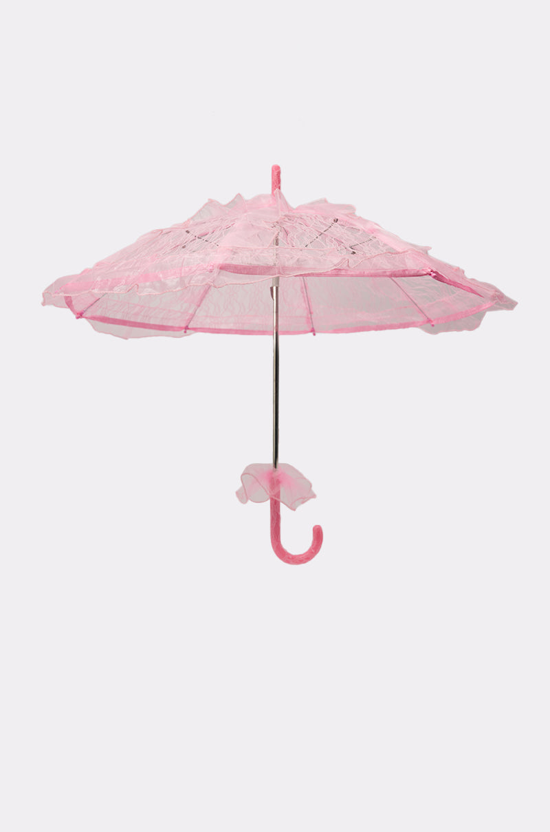The UNDER MY SPELL LACE UMBRELLA features vintage-inspired ruffled edges and a matching pink curved handle, beautifully displayed on a white background. 1
