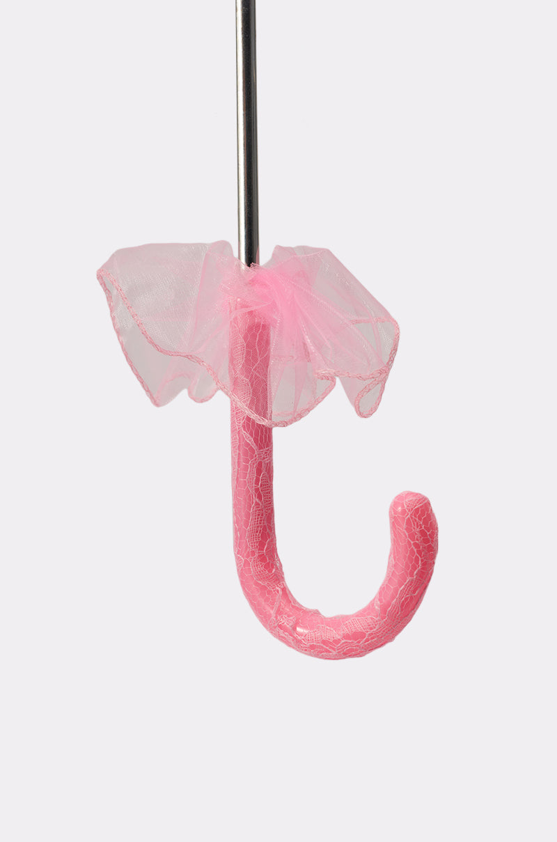 A close-up of the UNDER MY SPELL LACE UMBRELLA’s vintage handle, wrapped in textured material and adorned with a frilly pink tulle bow and scalloped edges, set against a plain white background. 3
