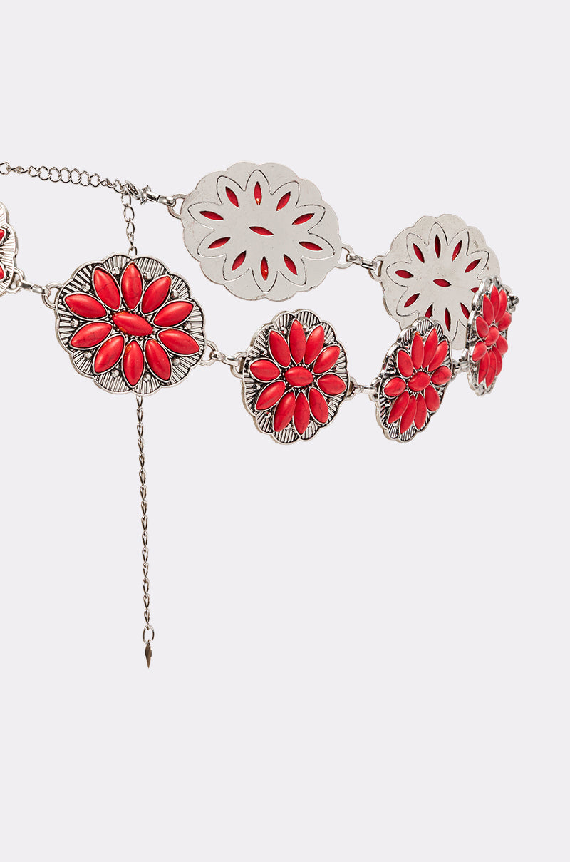 The THRU THE STORM BELT is a silver western vintage belt with large round conchos—some have red stone floral designs, others cut-out patterns—making it a standout boho-chic statement piece. 5