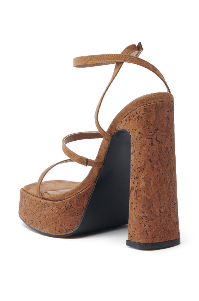 The AKIRA KNAPP BROWN CORK PLATFORM SANDAL features a suede-textile finish, chunky heel, black-sole, multiple thin straps, and a buckle-fastened ankle strap.