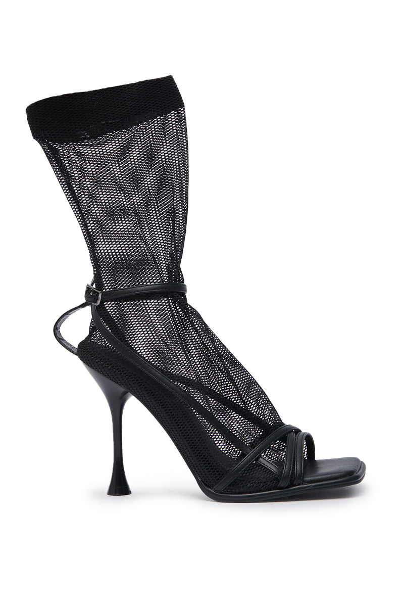 The AZALEA WANG KOHINA BLACK MESH SOCK DETAIL SANDAL is a black stiletto with a toe strap and an attached sheer mesh sock that rises above the ankle, creating a bold, modern style.