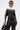 Wearing the WEST LOOP RACER MOTO black and white cropped moto jacket, lace-up black leather cutout pants, sunglasses, and holding a small black handbag, this person stands against a plain white background.