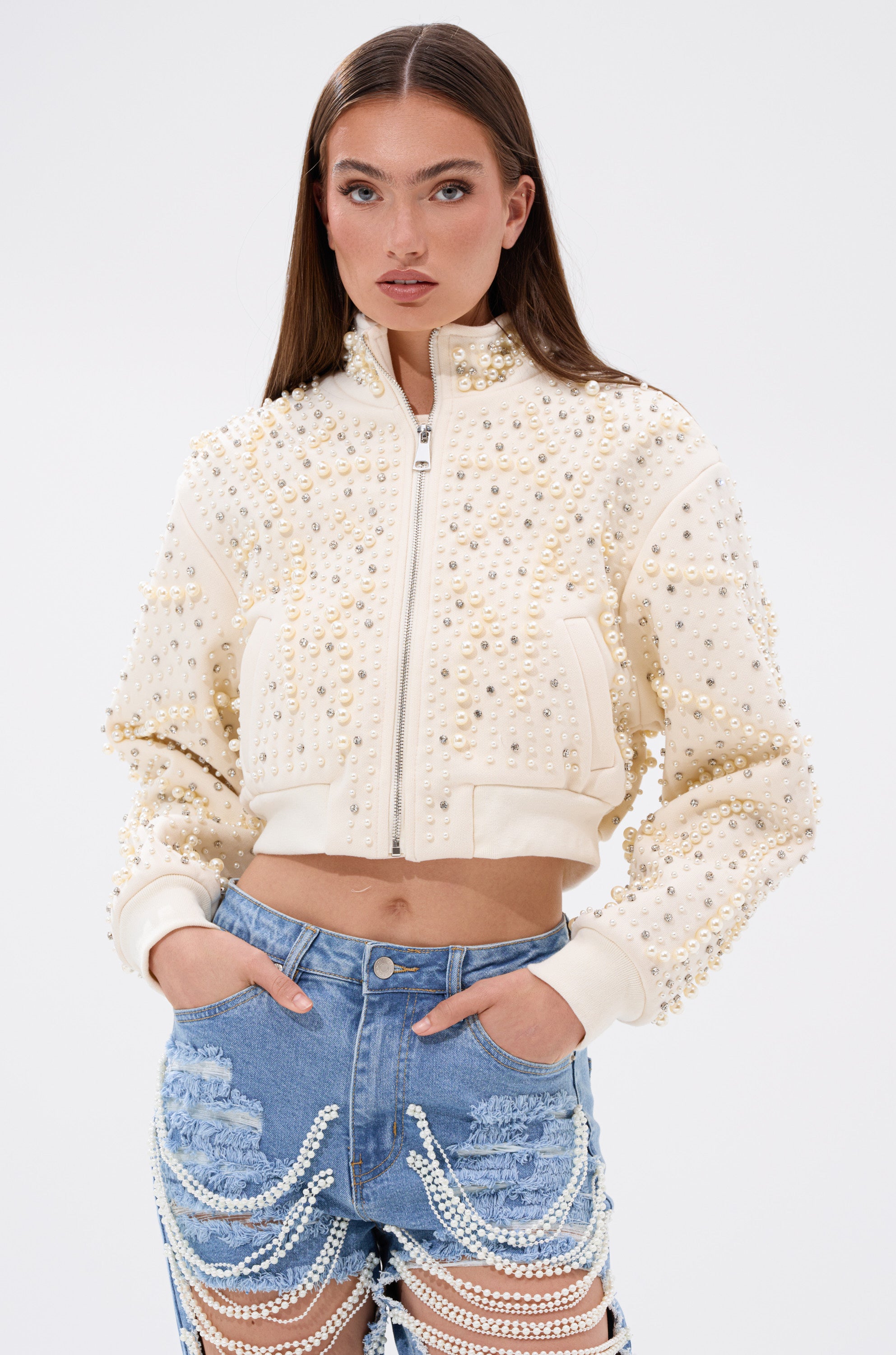 A woman in the AKIRA Label GOODIE TWO SHOES EMBELLISHED BOMBER, a pearl rhinestone jacket. 0