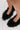 A close-up of a person's feet wearing the AZALEA WANG KURT Black Fur Embellished Pump on a light-colored surface.