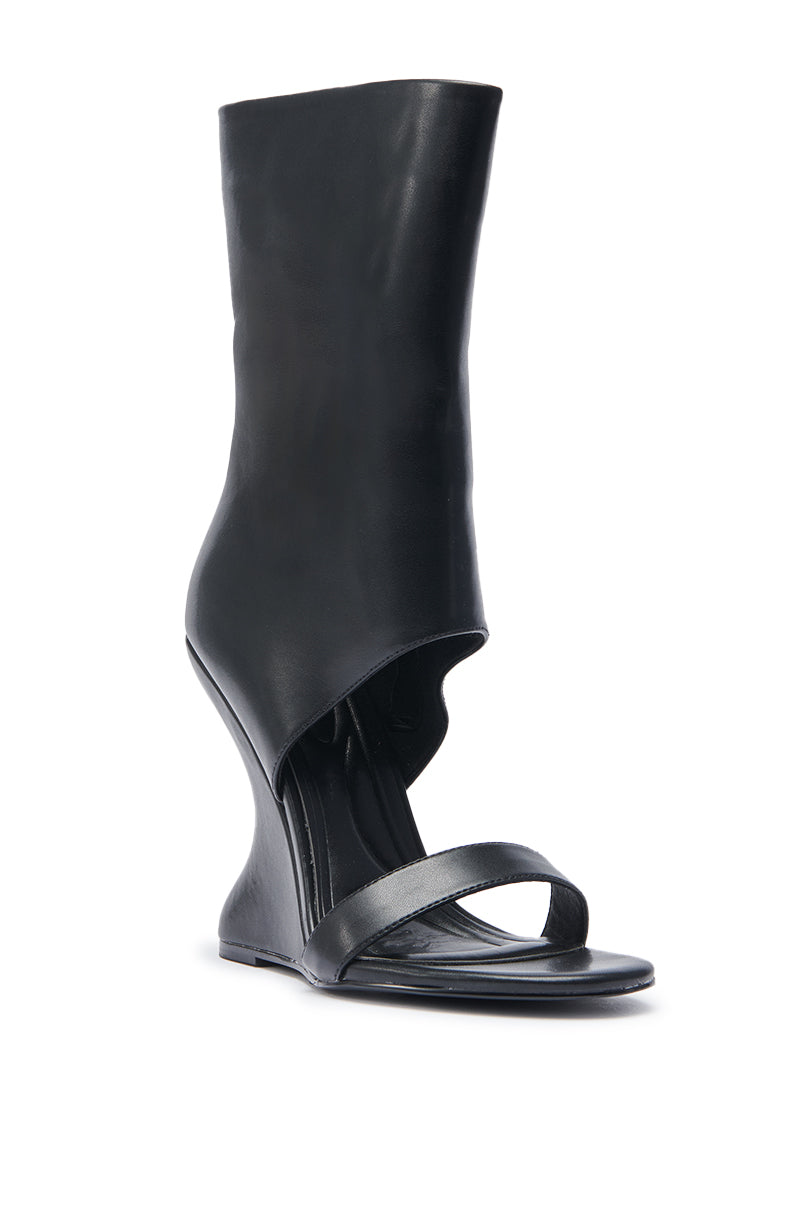 The AZALEA WANG KYVEKI BLACK WEDGE OPEN TOE BOOTIE features a black faux leather upper, sculptural inverted wedge heel, and tall asymmetrical design that covers the ankle and part of the lower leg for a sleek, modern look.