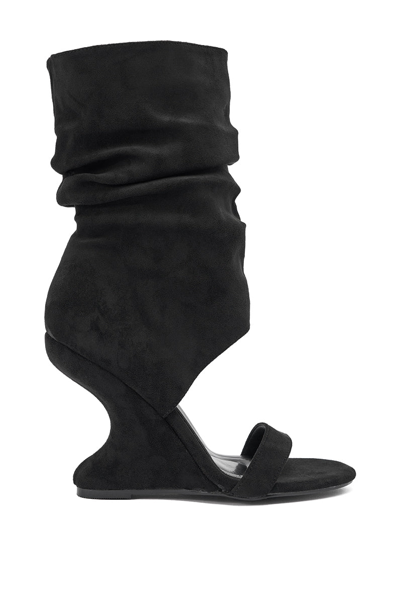 The AZALEA WANG KYVELISA BLACK WEDGE OPEN TOE BOOTIE features a sculptural wedge heel, single toe strap, and tall slouchy faux suede upper that covers the ankle and calf for a bold, modern look. 2