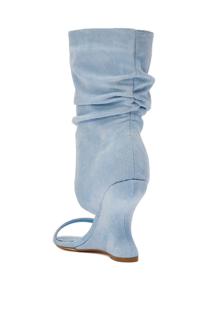 The AZALEA WANG KYVELISA BLUE WEDGE OPEN TOE BOOTIE features light blue faux suede, a slouchy mid-calf shaft, open toe, minimal front strap, curved sculptural wedge heel, and tan sole for a modern look. 6