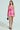 A woman channels her inner Legally Blonde, wearing an ELLE TWEED MINI DRESS with spaghetti straps against a soft backdrop. She carries a chic black handbag and dons sleek black heels. Her straight hair flows down as she gazes confidently at the camera.