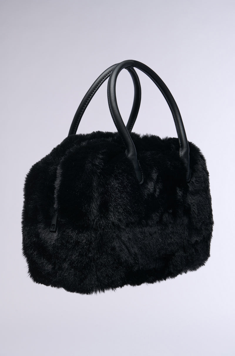 Introducing the TOO FURRY TO CARE FAUX FUR BAG, a sleek black handbag crafted from plush faux fur with dual leather handles set against a simple backdrop. Its soft texture is highlighted to present an elegant accessory that radiates luxury and sophistication.