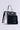 The TYPE IT OUT KEYBOARD PURSE boasts a sleek silver design with black keys and electronic circuit elements, crafted from recycled keyboard material. Its glossy faux patent leather finish and stylish handle beautifully merge fashion with technology.
