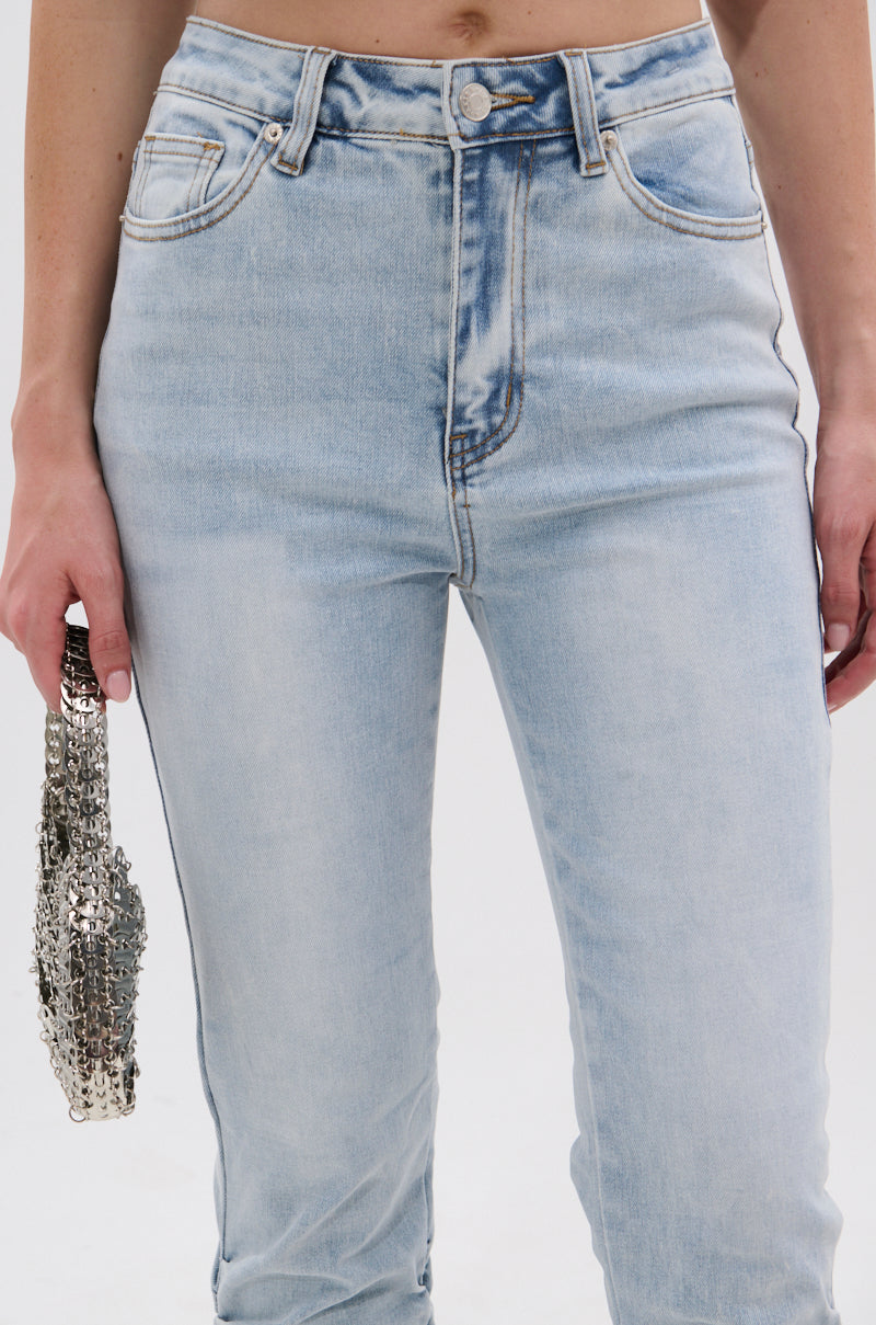 Wearing the LACE IT UP SKINNY DENIM PANT, a person holds a small silver beaded clutch in their left hand. They're styled with a corset-style top against a plain white background. 6