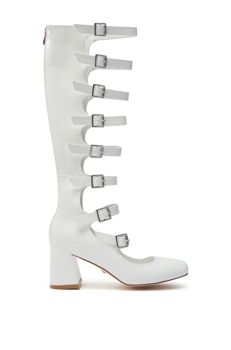 The AZALEA WANG LAIMA White Patent Chunky Buckle Boot is a knee-high design featuring an almond toe, seven horizontal straps with adjustable silver buckles, and a chunky block heel for a bold and stylish look. 3