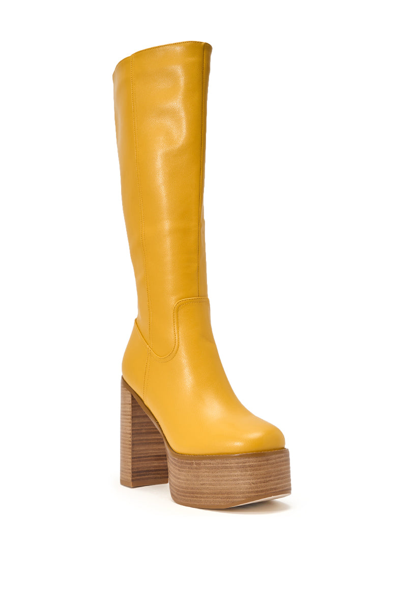 The AZALEA WANG LANDRY YELLOW PU WOOD STACK PLATFORM BOOT is a tall, knee-high yellow boot featuring a chunky wooden heel and sole, seen at a slight angle against a white background. 4
