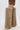 A person models the AZALEA WANG LAGANN BONE THIGH HIGH FUR LUXE BOOT, styled with brown leather shorts, against a plain white background.