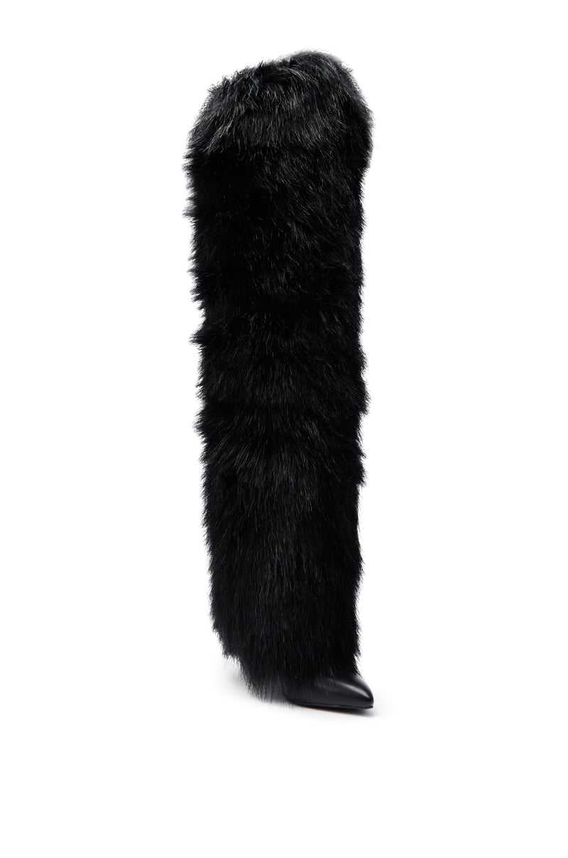 The AZALEA WANG LANGLEYE BLACK THIGH-HIGH FUR LUXE BOOT is a single tall boot wrapped in thick, shaggy black faux fur with a pointed toe at the base.