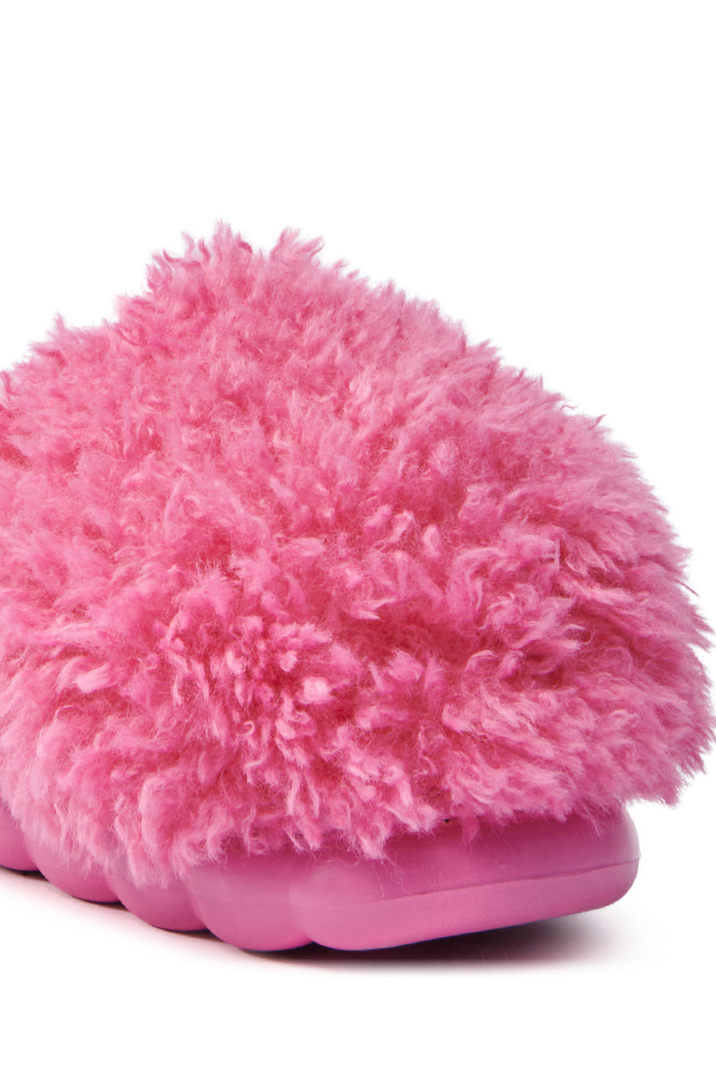 Close-up of the AZALEA WANG LAWSON PINK SLIPPER featuring a fluffy faux fur upper and solid pink flatform sole. This cozy design is perfect for indoor warmth and comfort against the crisp white background.