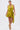 A woman models the STAR OF THE SHOW SATIN MINI DRESS, a sleeveless olive-green wrap-front mini with a deep V-neckline and asymmetrical hem, paired with matching heels and statement earrings, against a plain white background.