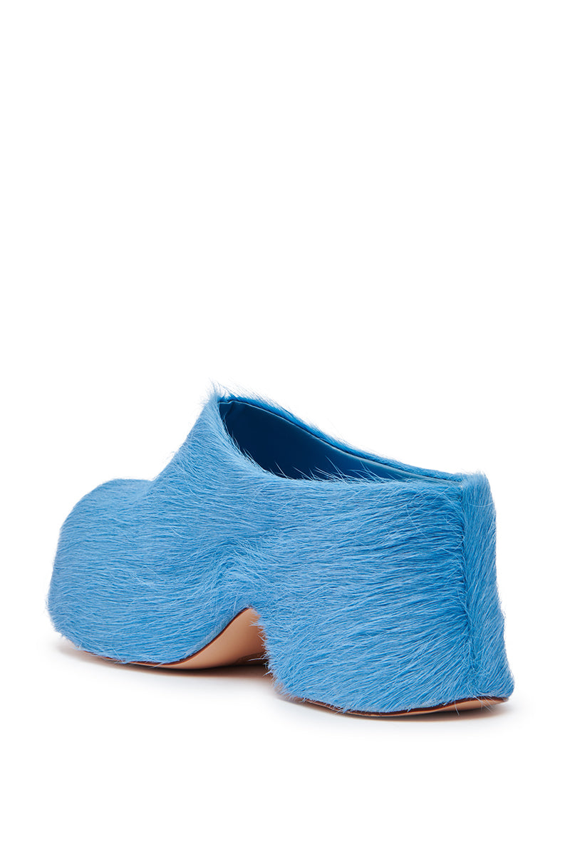 The AZALEA WANG LEESHA BLUE PONY HAIR CHUNKY CLOG is a boldly sculpted shoe in vibrant blue faux fur with a chunky heel, shown against a white background.
