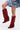 A person poses with one leg raised against a plain light background, wearing a blue denim skirt and AZALEA WANG LETTICE Burgundy Faux Suede Western Boot with a chunky heel.