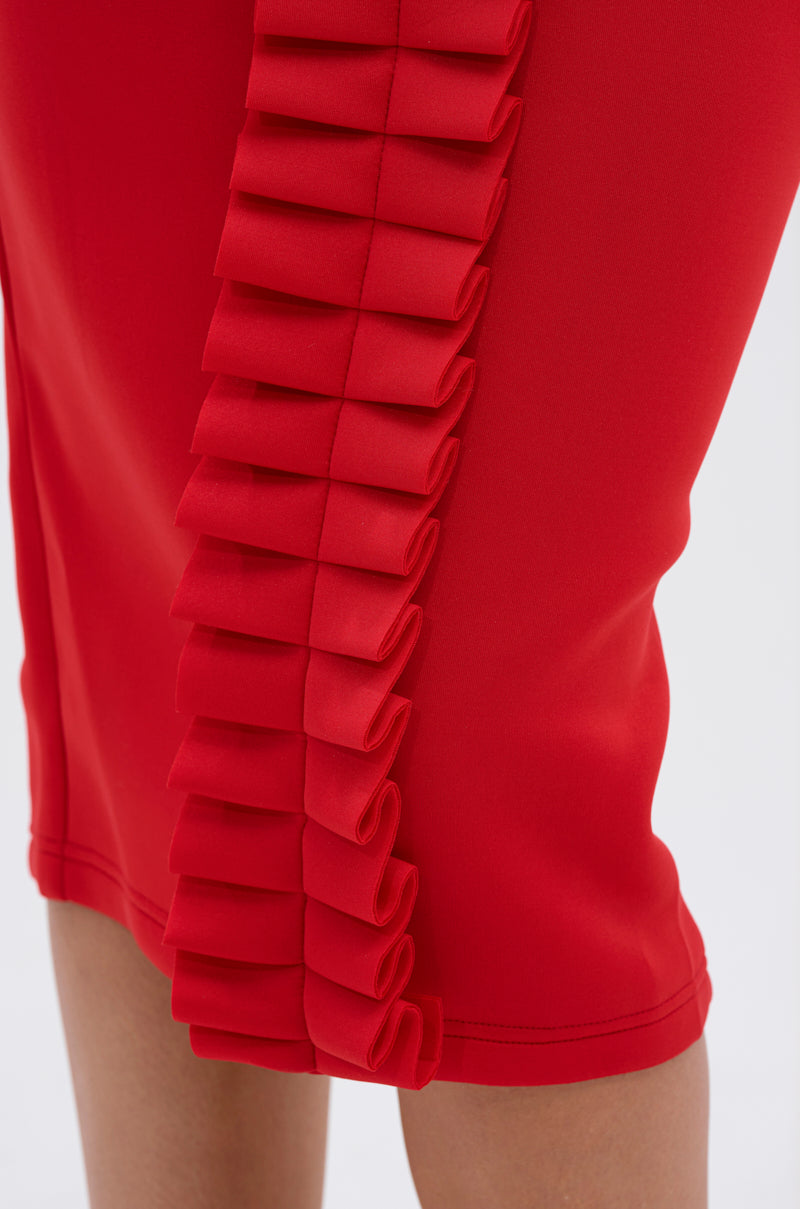 Close-up of the PURE JOY MIDI DRESS WITH DRAMATIC SLEEVE IN RED, showcasing its bold color, bodycon fit, and a striking vertical ruffle detail with neatly folded pleats along the side seam.
