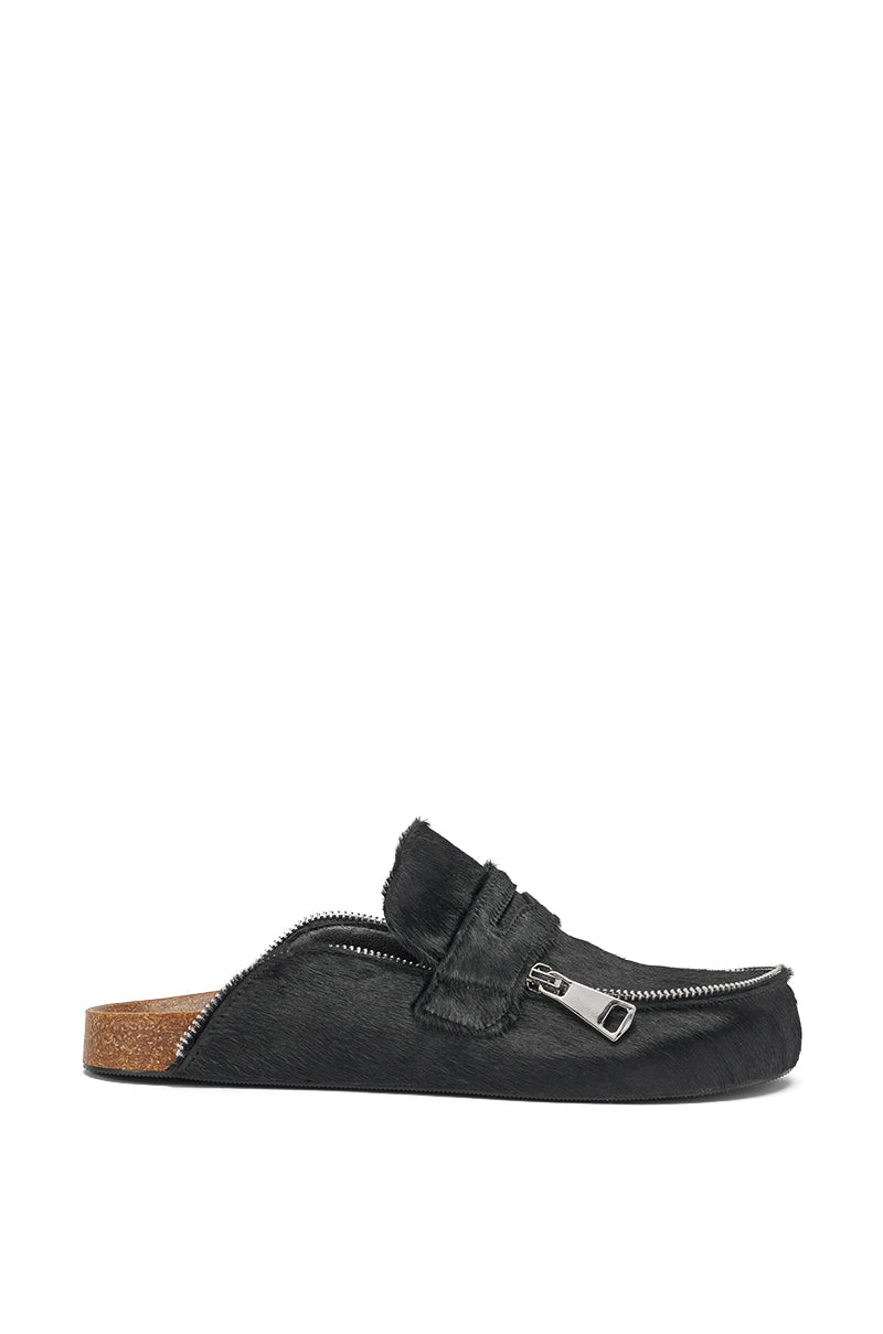The AZALEA WANG LIMERICK BLACK METAL EMBELLISHMENT FLAT is a black calf-hair backless mule with a cork sole, textured furry upper, and bold silver zipper detail. Photographed from the side on a white background. 4