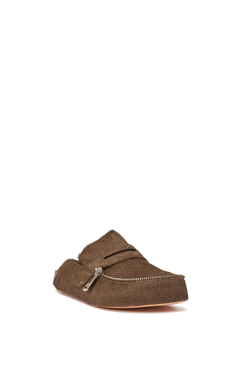 The AZALEA WANG LIMERICK CHOCOLATE METAL EMBELLISHMENT FLAT is a chocolate brown calf hair mule loafer with a textured, fur-like surface, metal zipper details, and a slightly pointed toe. Slip-on design shown against a white background. 4