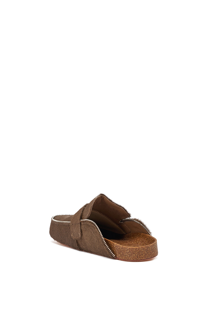 The AZALEA WANG LIMERICK CHOCOLATE METAL EMBELLISHMENT FLAT is a brown slip-on mule with a cork sole, open toe, and furry calf hair texture, shown from the back on a white background. 5