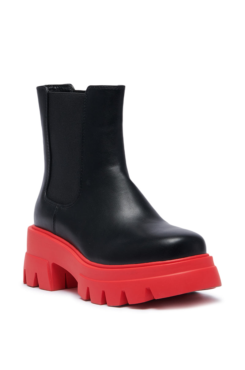 The AZALEA WANG LINDIE BLACK BOOTIE is a black leather ankle boot featuring a chunky, vibrant red platform lug sole with deep treads. This design incorporates an elastic side panel for easy wear, making it stand out by seamlessly blending bold style with practicality.