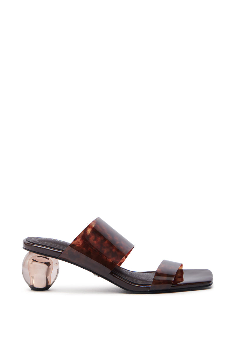 Side view of the AZALEA WANG LIRIO BROWN BALL HEEL SANDAL, showcasing fashionable brown sandals with two thick, translucent tortoiseshell-patterned straps, a dark sole, and a glossy round metallic sphere as a novelty heel against a white background.