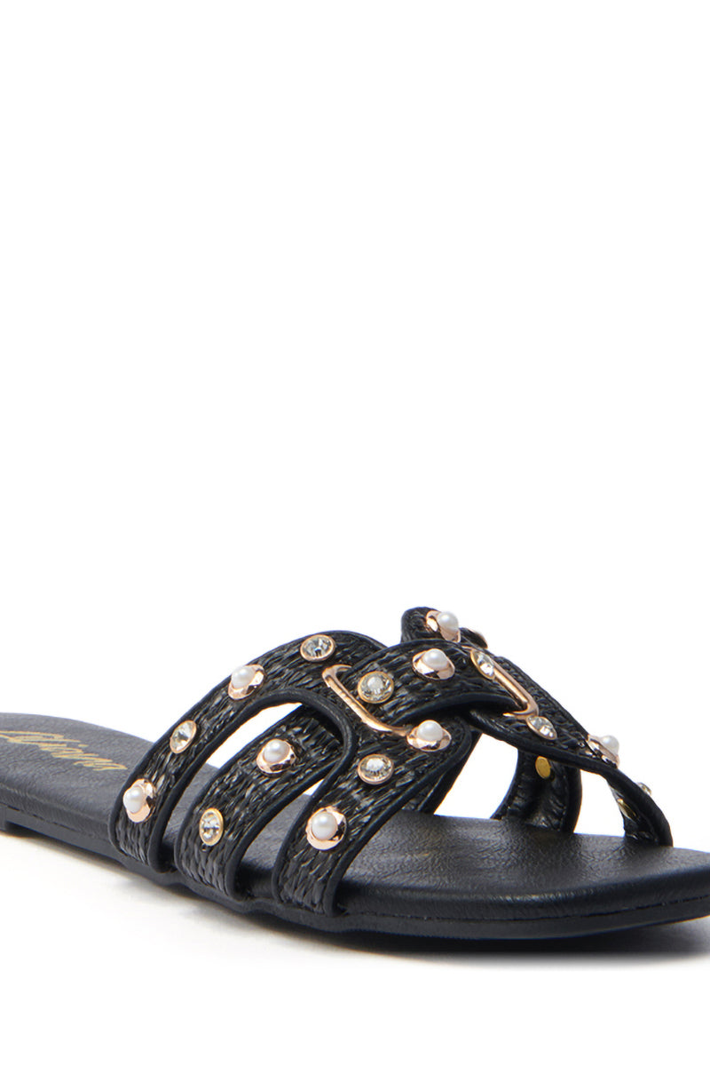 The LISA Black Embellished Slip-On Sandal features multiple crisscross straps with shiny stones and pearl-like accents on a plain white backdrop. Its open square-toe design brings a modern touch to this chic sandal.