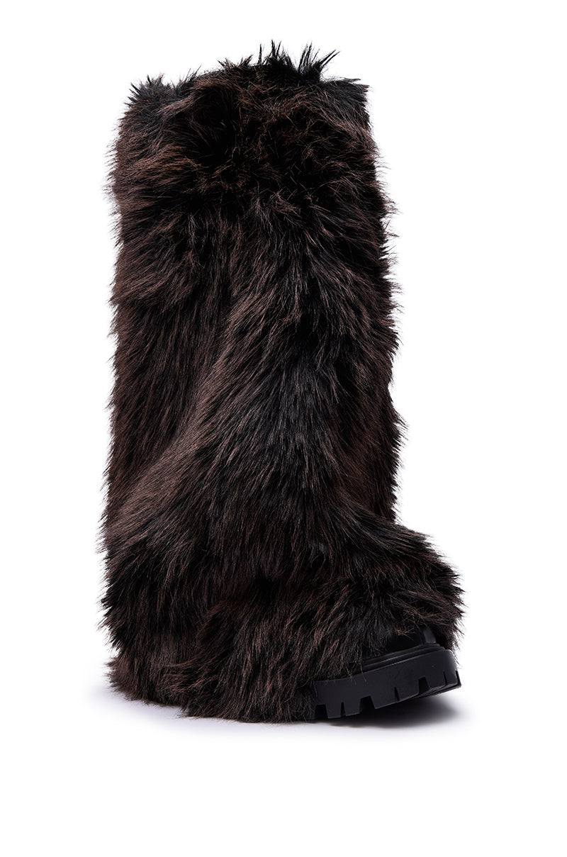The AZALEA WANG LISBOA BROWN FUR FOLD OVER BOOT is a knee-high boot with thick brown and black faux fur and a chunky black sole, shown standing upright against a white background.