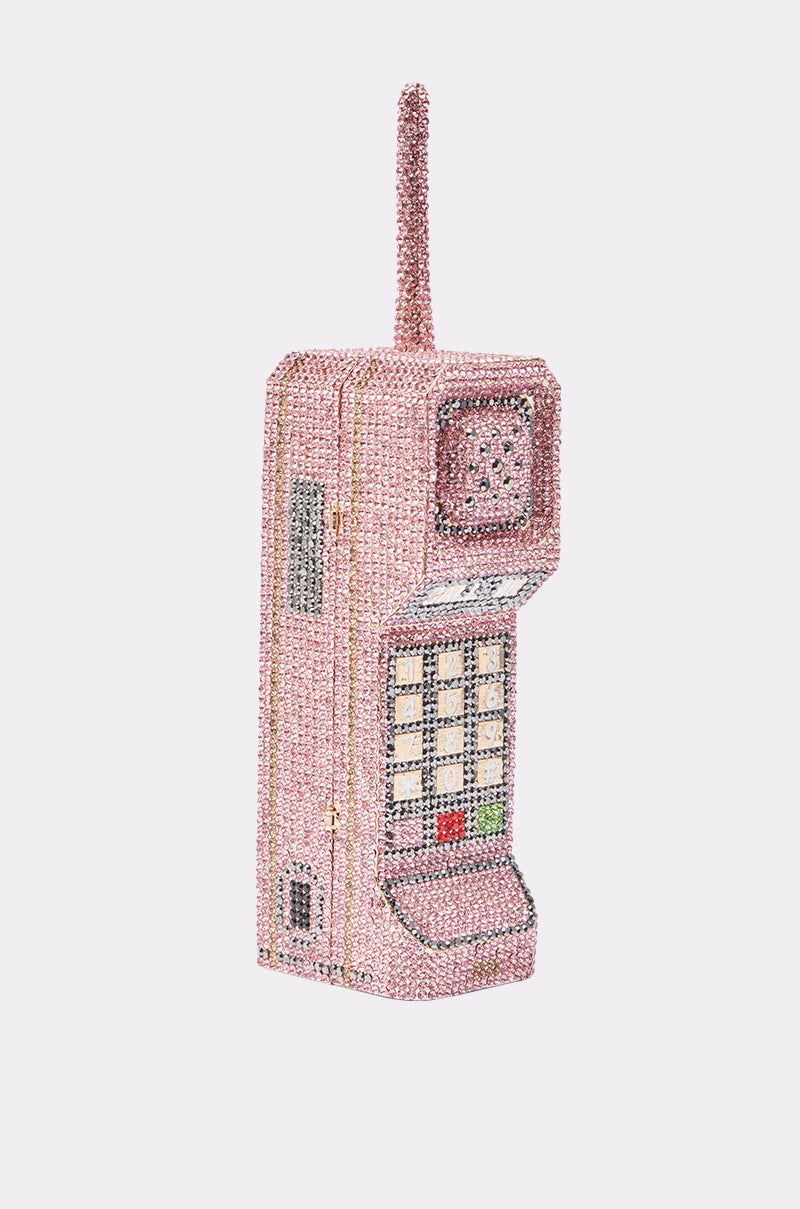 The HIT MY LINE BLING PURSE is a Y2K-inspired handbag shaped like a vintage brick cellphone, featuring pink and multicolored rhinestones, a beaded antenna, and keypad for a bold, playful statement look. 0