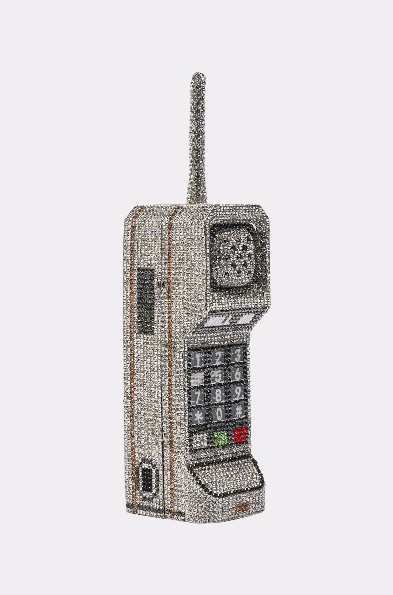 The CALL ME BLING CLUTCH is a sculpture of a vintage brick cell phone, dazzling with rhinestones, featuring a long antenna and keypad, and styled to resemble a glamorous clutch. 5