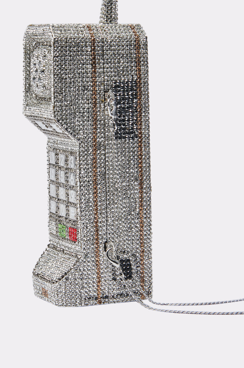 The CALL ME BLING CLUTCH is a phone-shaped purse with silver rhinestones, a chain strap, keypad details, and metallic accents for a sparkling vintage cell phone look.